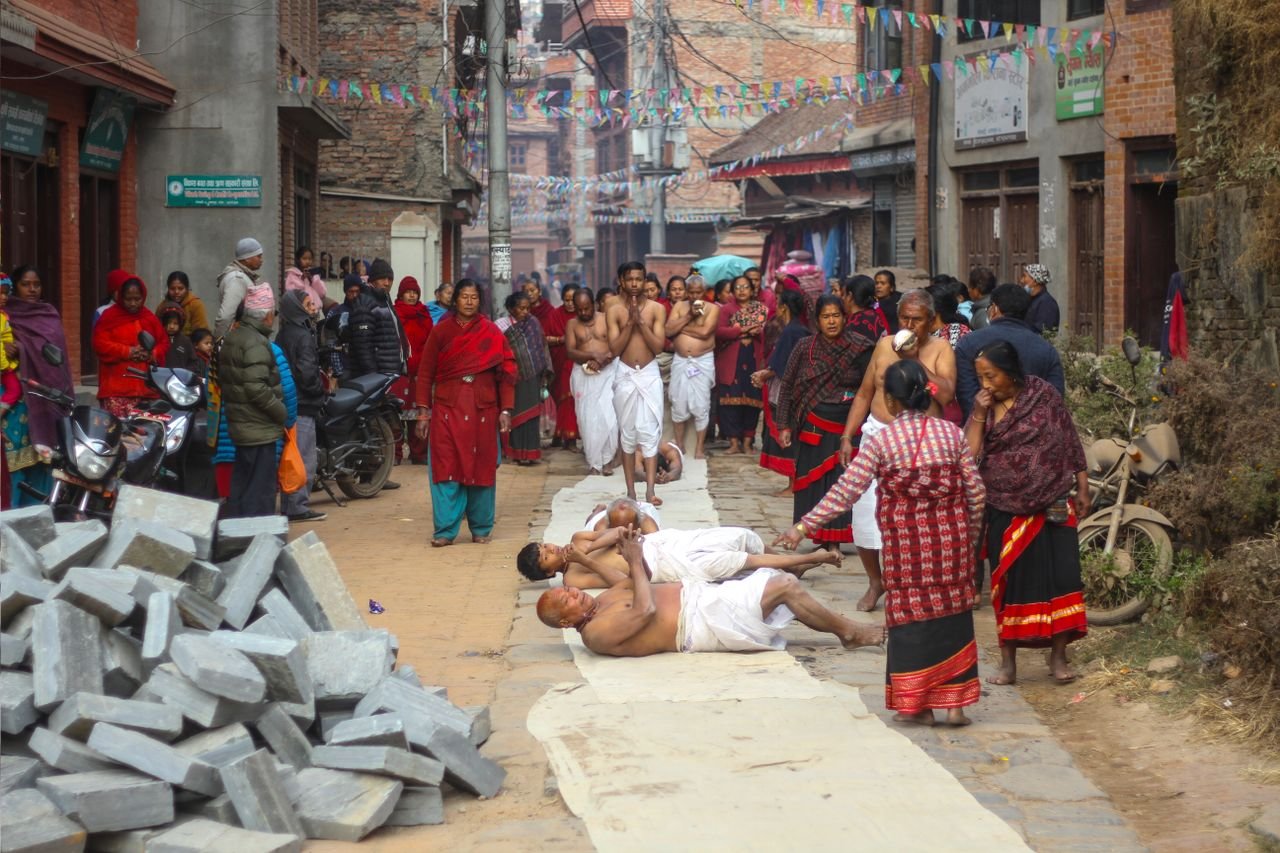 A vibrant traditional festival scene with people in Bhaktapur, Nepal, showcasing cultural rituals.