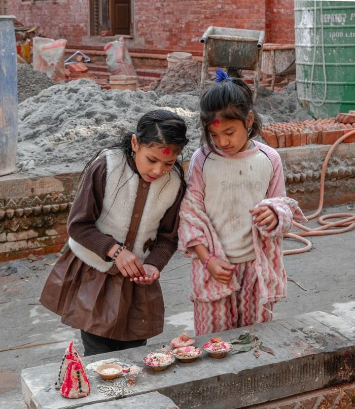 Two young girls participate in a traditional ceremony in Kathmandu, Nepal.